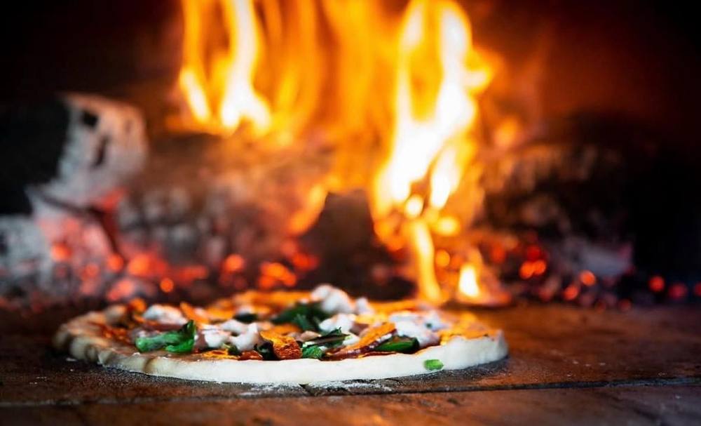 12-inch pizza cooking in the wood-fired oven at Wood Grill at The Queen Adelaide